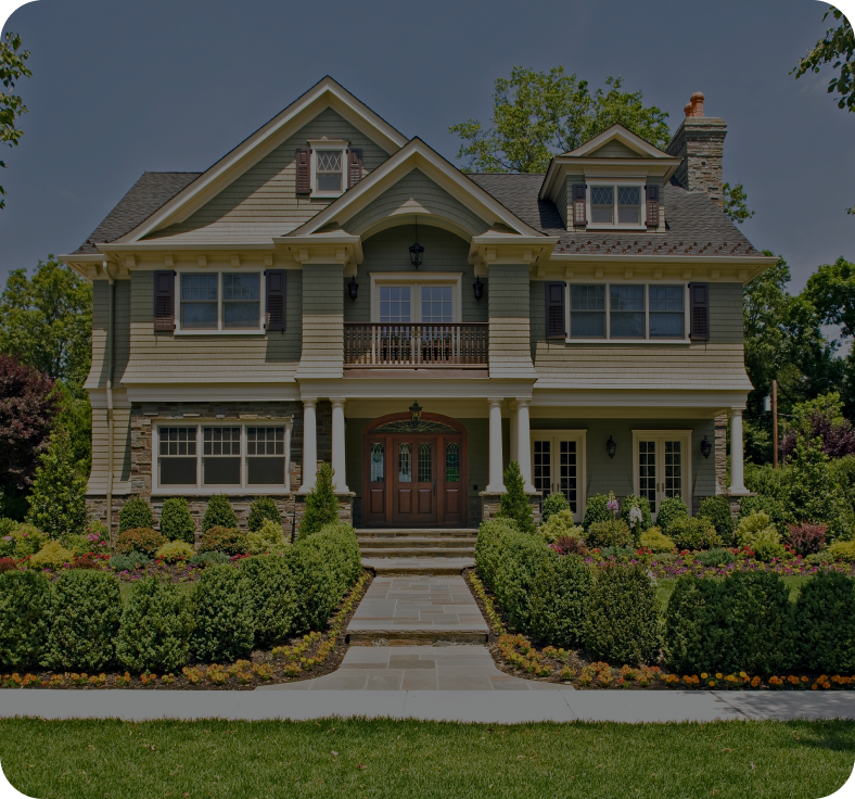 A large house with many bushes around it